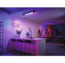 Cameră de zi cu lumini de tavan și două persoane la un bar de bucătărie