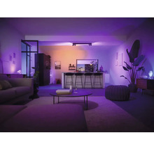 Cameră de zi cu canapea, masă, scaune de bar și iluminat inteligent pentru o ambianță plăcută.