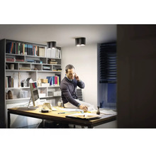 Scenă de birou cu un bărbat la birou, bibliotecă și lămpi de tavan