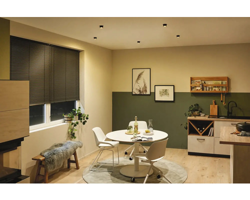 Sufragerie cu masă, scaune, fereastră cu jaluzele și corpuri de iluminat de tavan.