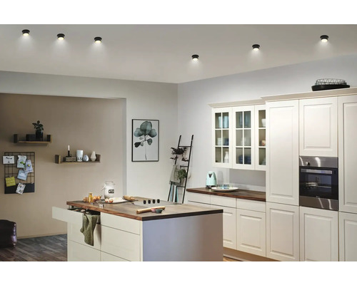 Bucătărie luminoasă cu insulă de gătit și lămpi de tavan rotunde