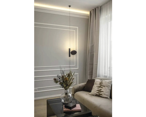 Scenă modernă de living cu lampă suspendată, canapea, perne, măsuță de cafea și vază cu flori.