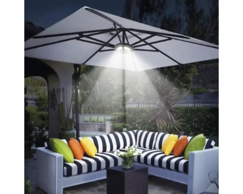 Scenă cu un grup de relaxare sub o umbrelă de soare iluminată