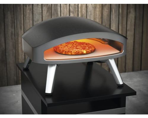 Cuptor de pizza cu pizza în interior pe o masă