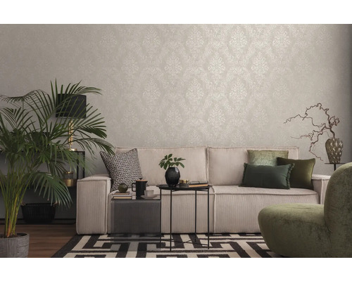 Cameră de zi cu tapet cu model, canapea, plantă de interior și elemente decorative pentru o ambianță confortabilă