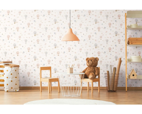Cameră pentru copii cu tapet cu model de baloane cu aer cald, masă, scaune și jucării