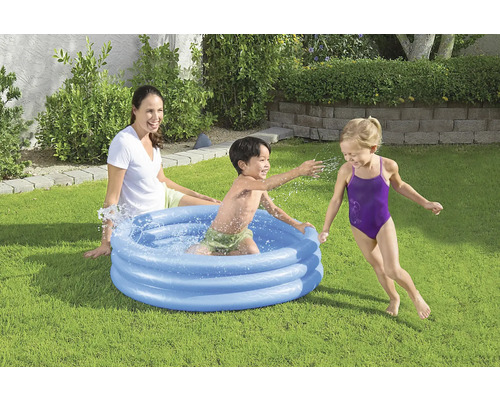 Piscină gonflabilă pentru copii cu copii jucându-se și o femeie în grădină.