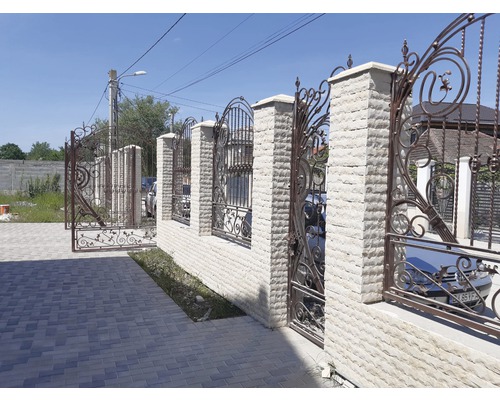 Poartă de intrare cu elemente metalice decorative și stâlpi ziditi