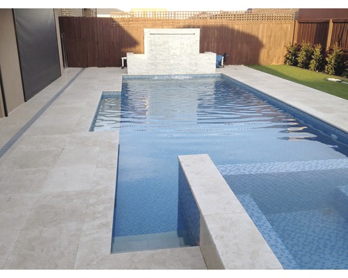 Piscină cu plăci de piatră și cascadă în grădină