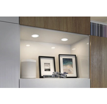 Spoturi încastrate care iluminează un raft cu obiecte decorative într-un interior modern.