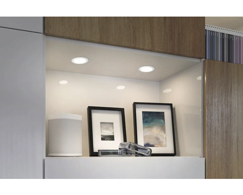 Spoturi încastrate care iluminează un raft cu obiecte decorative într-un interior modern.