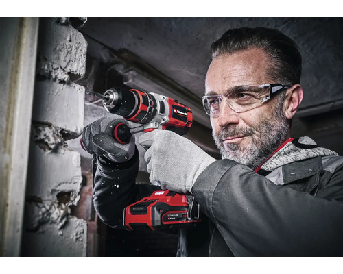 Bărbat care găurește un perete de cărămidă cu o șurubelniță cu acumulator Einhell