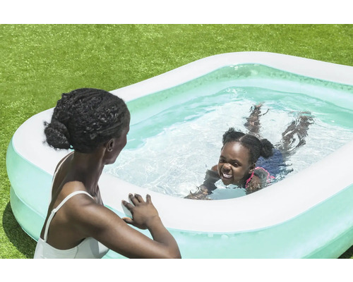 Mamă și copil în piscină gonflabilă în grădină