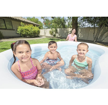 Copii se joacă într-o piscină gonflabilă în grădină.