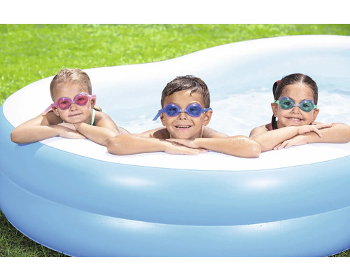 Trei copii cu ochelari de înot se relaxează într-o piscină gonflabilă în grădină.