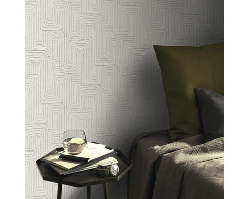 Dormitor cu tapet geometric, noptieră, pat și decorațiuni pentru o ambianță primitoare.