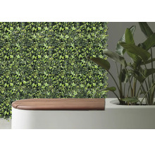 Placare decorativă a peretelui cu iederă artificială lângă o bancă și o plantă de apartament.