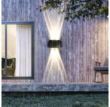 Lumină de perete exterioară iluminată pe un perete de lemn lângă o fereastră și un balansoar.