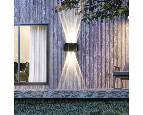 Lumină de perete exterioară iluminată pe un perete de lemn lângă o fereastră și un balansoar.