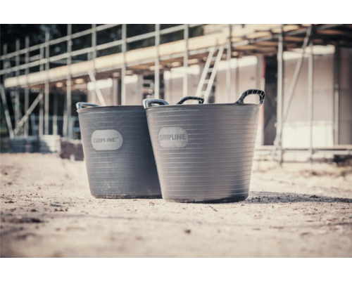 Două cuve de mortar din plastic cu mânere pe un șantier