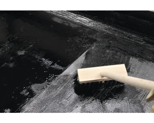 Aplicarea rășinii epoxidice cu o pensulă pe o rogojină din fibră de sticlă