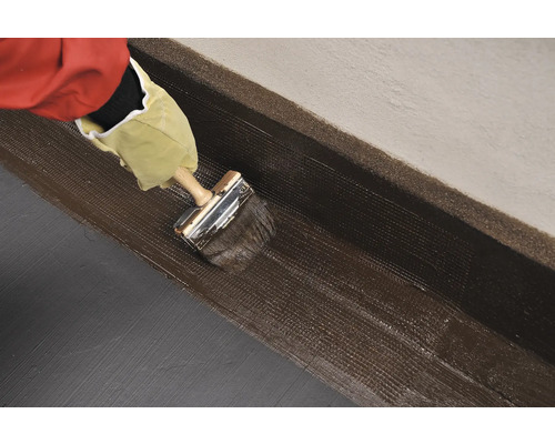 Aplicarea etanșantului cu o pensulă pe un perete.