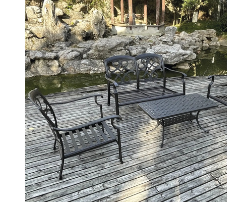 Set de mobilier de grădină cu masă, bancă și scaun pe o terasă de lemn lângă un iaz