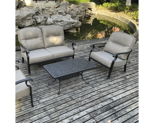 Set de mobilier de grădină cu canapea, două scaune și o masă pe o terasă din lemn