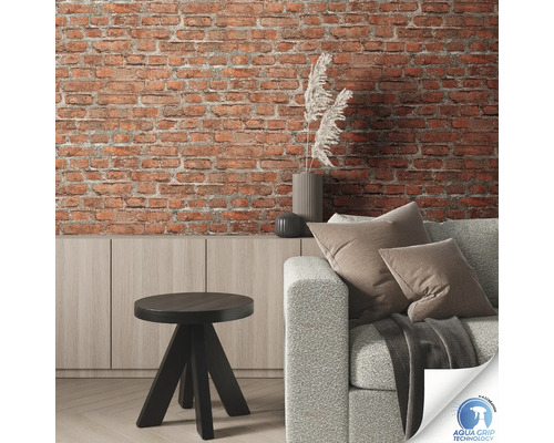 Living cu perete de cărămidă, canapea, masă și comodă