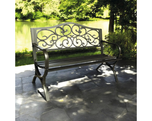 Bancă de grădină metalică cu spătar decorativ în fața unui lac