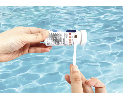 Persoană care testează salinitatea unei piscine cu o bandă de testare