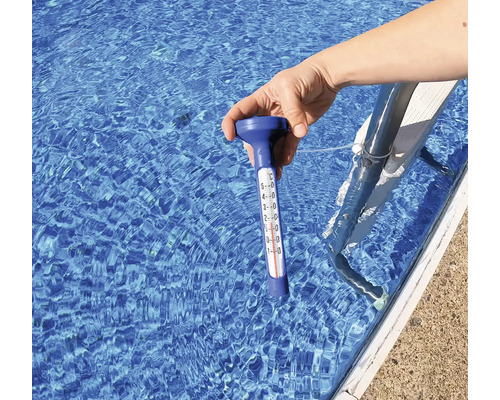 Mână ține termometru de piscină în apă