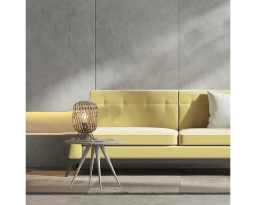 Scenă cu lampă de masă din ratan pe o măsuță laterală în fața unei canapele galbene.