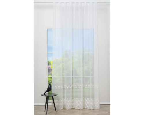 Cortină cu model floral în fața unei ferestre