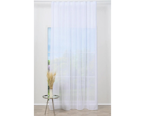 Draperie albă cu ochiuri în fața ferestrei, cu măsuță laterală și decorațiuni