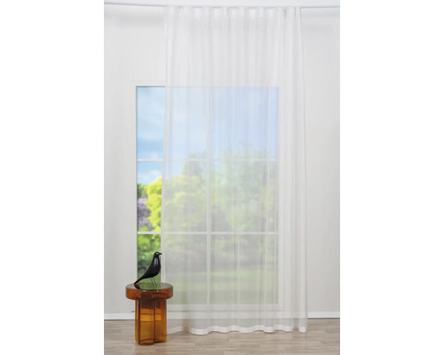 Fereastră cu țesătură de perdea transparentă și masă decorativă