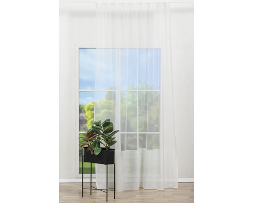 Cameră luminoasă cu fereastră, perdea și plantă de interior în jardinieră