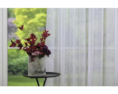 Aranjament decorativ cu vază și perdea transparentă la fereastră