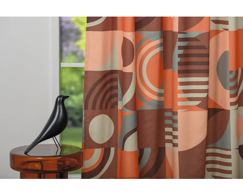 Cortină decorativă cu modele geometrice în fața unei ferestre