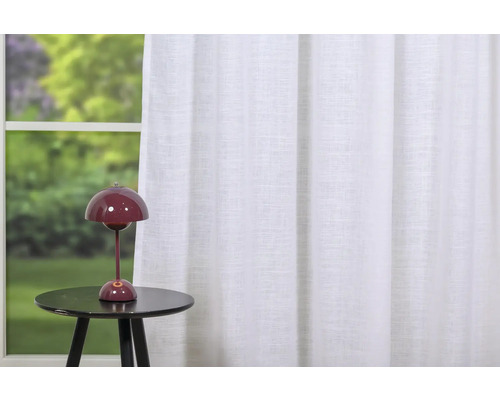 Scenă cu perdea albă și lampă de masă pe o măsuță laterală