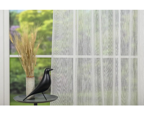 Scenă decorativă cu perdea transparentă, vază cu grâu și figurină de pasăre pe o masă