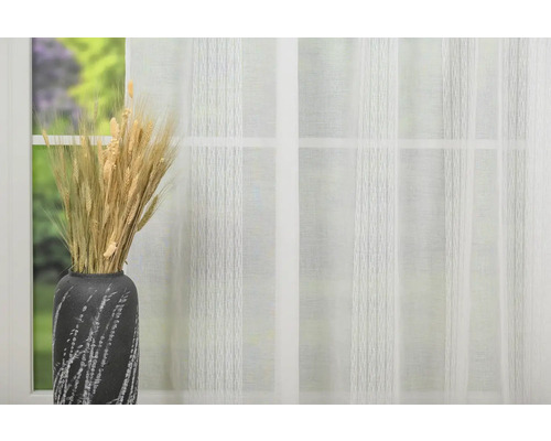 Spice decorative de grâu în vază în fața unei ferestre cu perdea