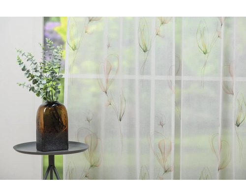 Fereastră decorativă cu perdea transparentă cu model floral și vază cu eucalipt pe o masă