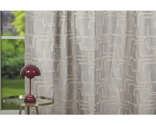 Perdea decorativă cu model geometric lângă o lampă de masă