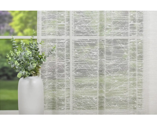 Material decorativ, transparent, cu model, pentru perdele, în fața unei ferestre.