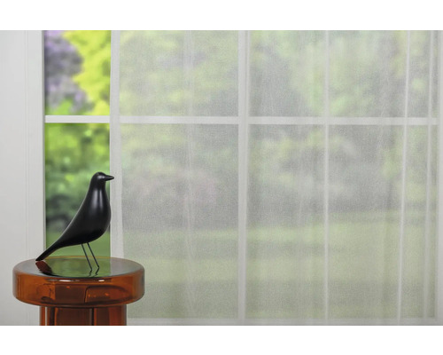 Vedere de la fereastră cu perdea transparentă și figurină decorativă pasăre