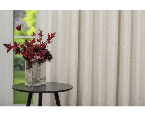 Cortină bej decorativă lângă o masă cu o vază cu flori