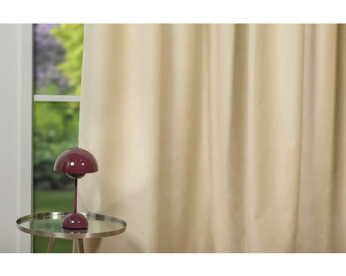 Perdea bej lângă o fereastră cu o lampă pe o măsuță laterală