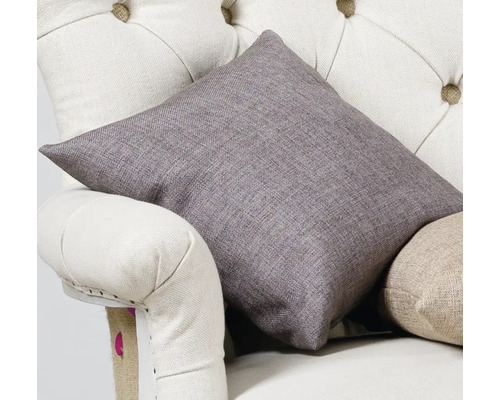 Pernă decorativă din stofă pe un fotoliu