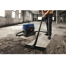Artizan care curăță un șantier cu un aspirator industrial Bosch.